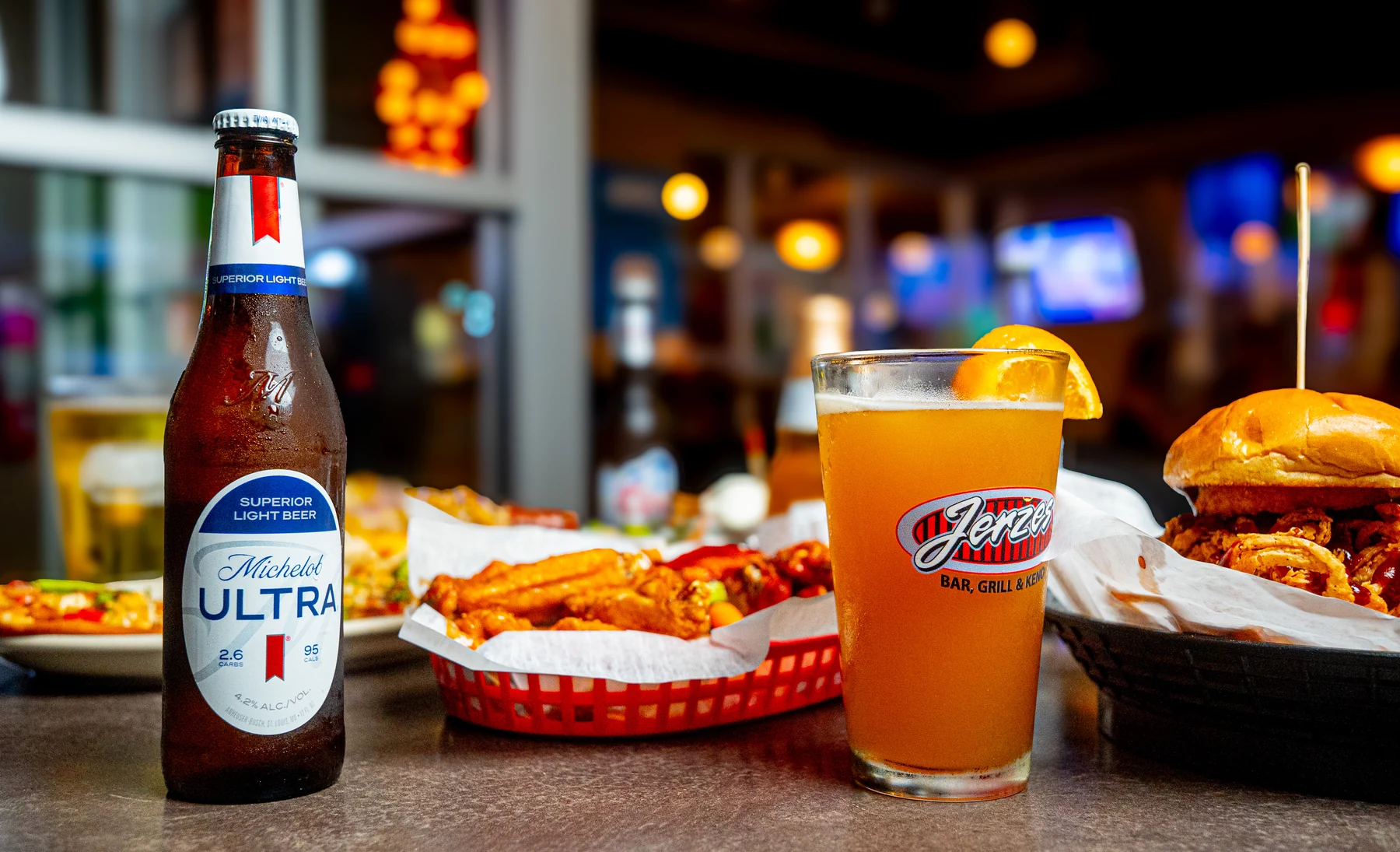 Wings, a burger, and a Jerzes pint on the table